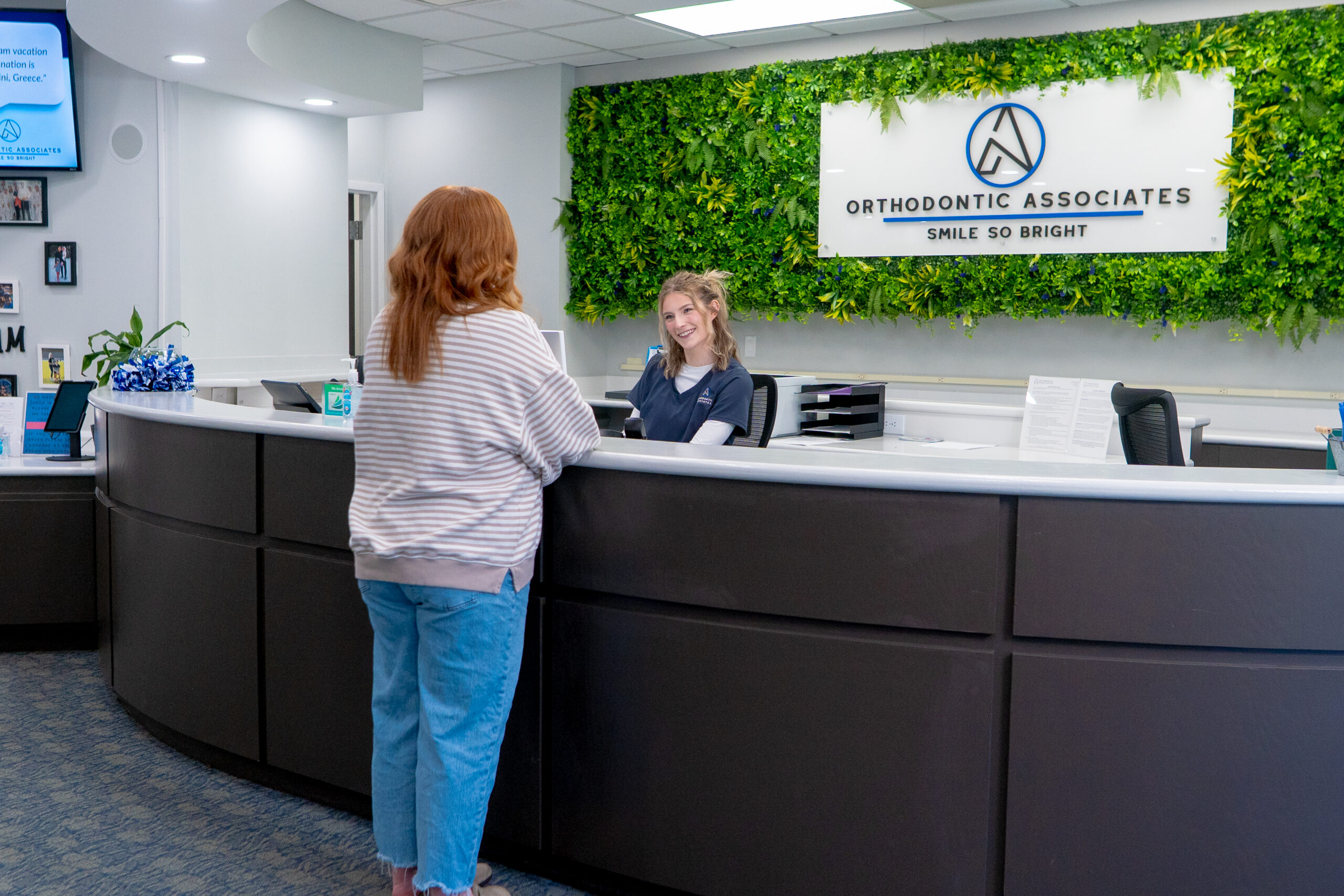 Patient checking in at the front desk during a first orthodontic visit